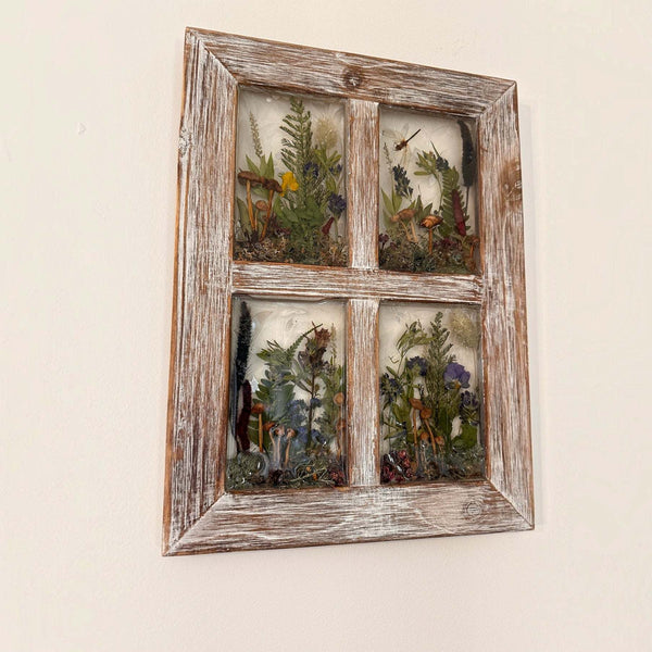 Pressed flower window art in a distressed whitewashed wood frame, with four resin panes of colorful pressed botanicals and greenery