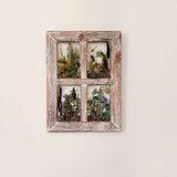 pressed flower window art in a distressed whitewashed wood frame, with four clear panes holding colorful ferns and wildflowers
