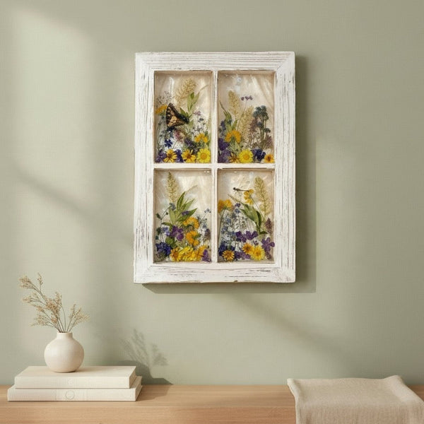 Pressed flower window art held up to the winter light, showing the translucent resin panes