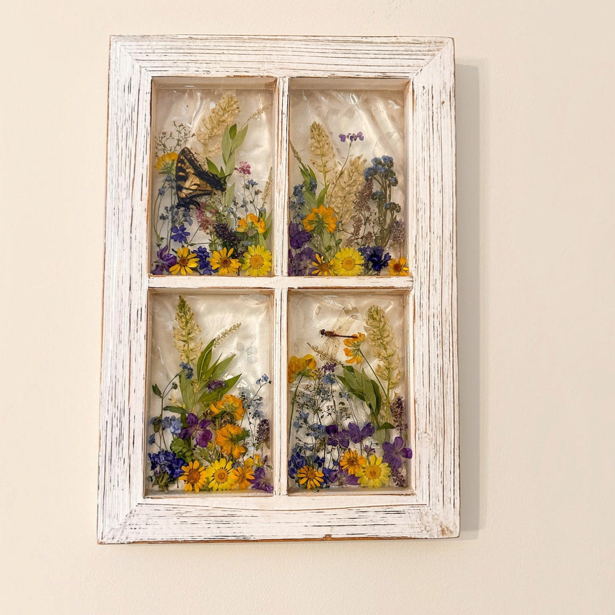 Close up of pressed pansies, buttercups and forget me nots in the pressed flower window art