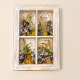 Close up of pressed pansies, buttercups and forget me nots in the pressed flower window art