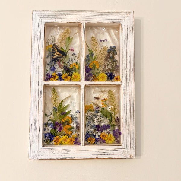 Close up of pressed pansies, buttercups and forget me nots in the pressed flower window art