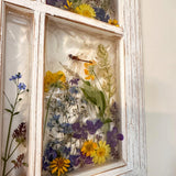 Pressed flower window art styled on a wall as handmade botanical decor from Alberta