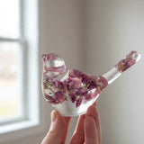 Purple lupine resin bird held in a hand to show its small size