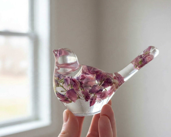 Purple lupine resin bird held in a hand to show its small size
