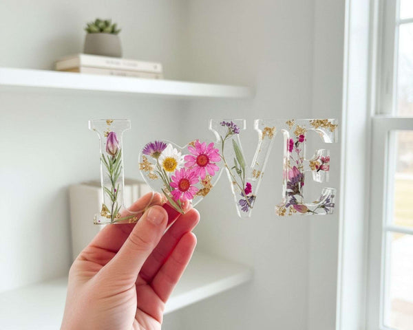 Wildflower resin LOVE word art with pink daisies, purple wildflowers, rose buds, and gold leaf flakes