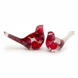 Close-up of glossy red berries suspended in clear hand-poured resin bird with red glitter shimmer