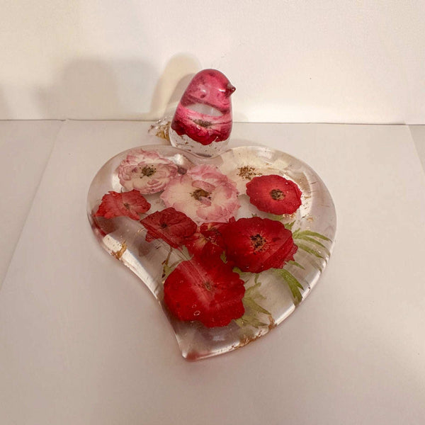 Rose heart trinket dish in clear resin with pressed red and pink flowers, green leaves, gold flecks and a matching bird