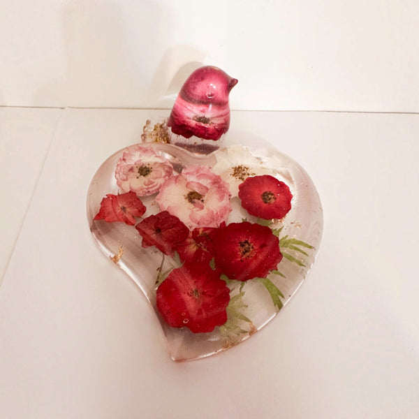 rose heart trinket dish in clear resin with red and pink pressed roses, green leaves, gold accents and a matching pink songbird