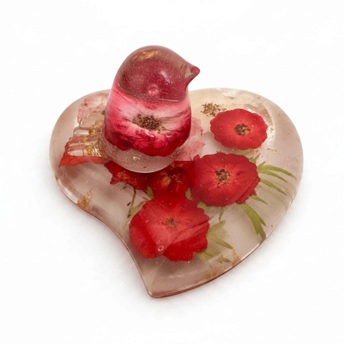 rose heart trinket dish in clear resin with red pressed roses, green botanicals, gold leaf and a matching rose-filled bird