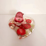 Rose heart trinket dish in clear resin with pressed red roses, green botanical accents and a matching pink songbird