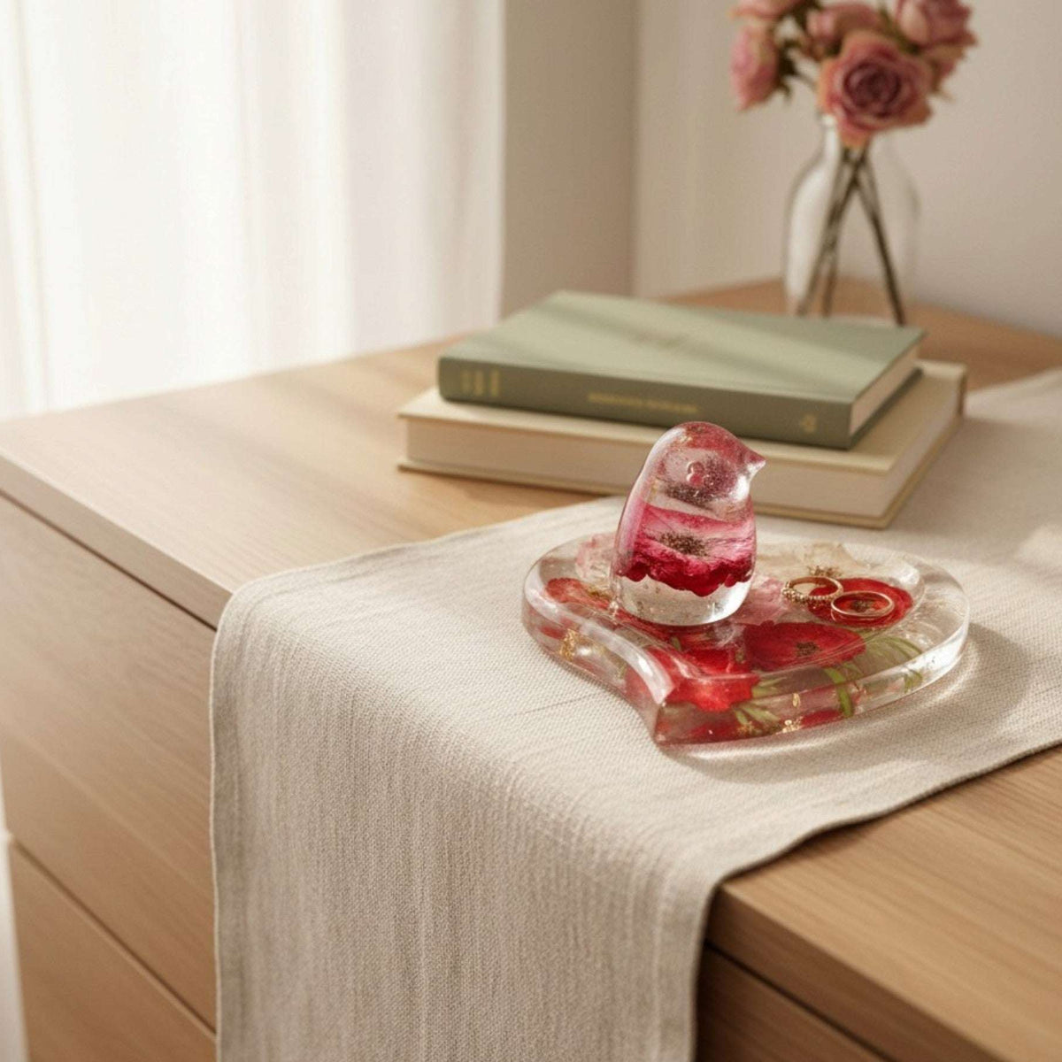 Rose heart trinket dish in clear glossy resin with red and pink pressed roses, green botanicals, gold leaf, and a matching rose-filled songbird.