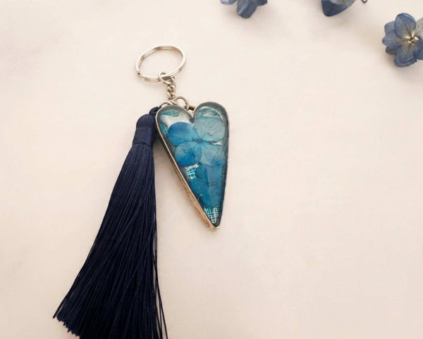Sapphire Heart keychain with a blue dried flower in a glossy resin silver heart and a long navy tassel