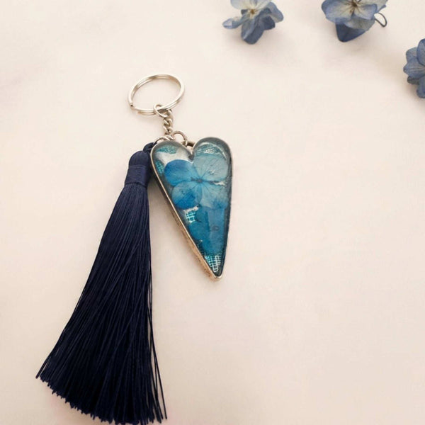 Sapphire Heart keychain with a blue dried flower in a glossy resin silver heart and a long navy tassel