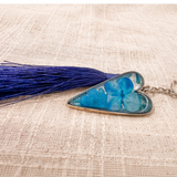 Sapphire Heart keychain with vivid blue flowers preserved in a silver-edged resin heart and a navy tassel