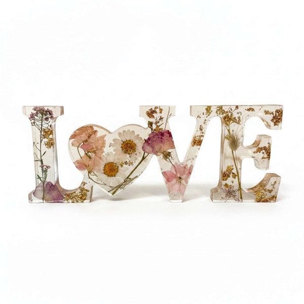 Whispering Meadow LOVE resin word art with white daisies, blush pink and purple wildflowers, bunny tail, and gold leaf flakes