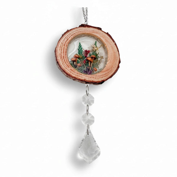 Suncatcher with a natural wood slice frame, miniature mushroom and fern scene, and clear faceted crystal drops