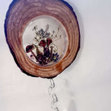 Suncatcher with a natural bark-edged wood slice, clear resin forest scene of mushrooms and botanicals, and hanging crystal